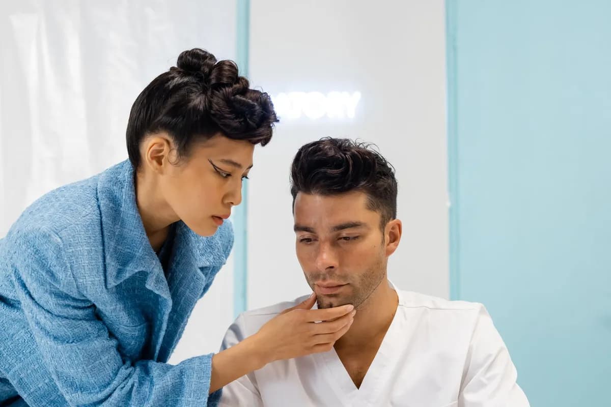 Medical professional examining a male patient's hair loss — Norwood scale assessment, Carisma Hair Clinic Malta