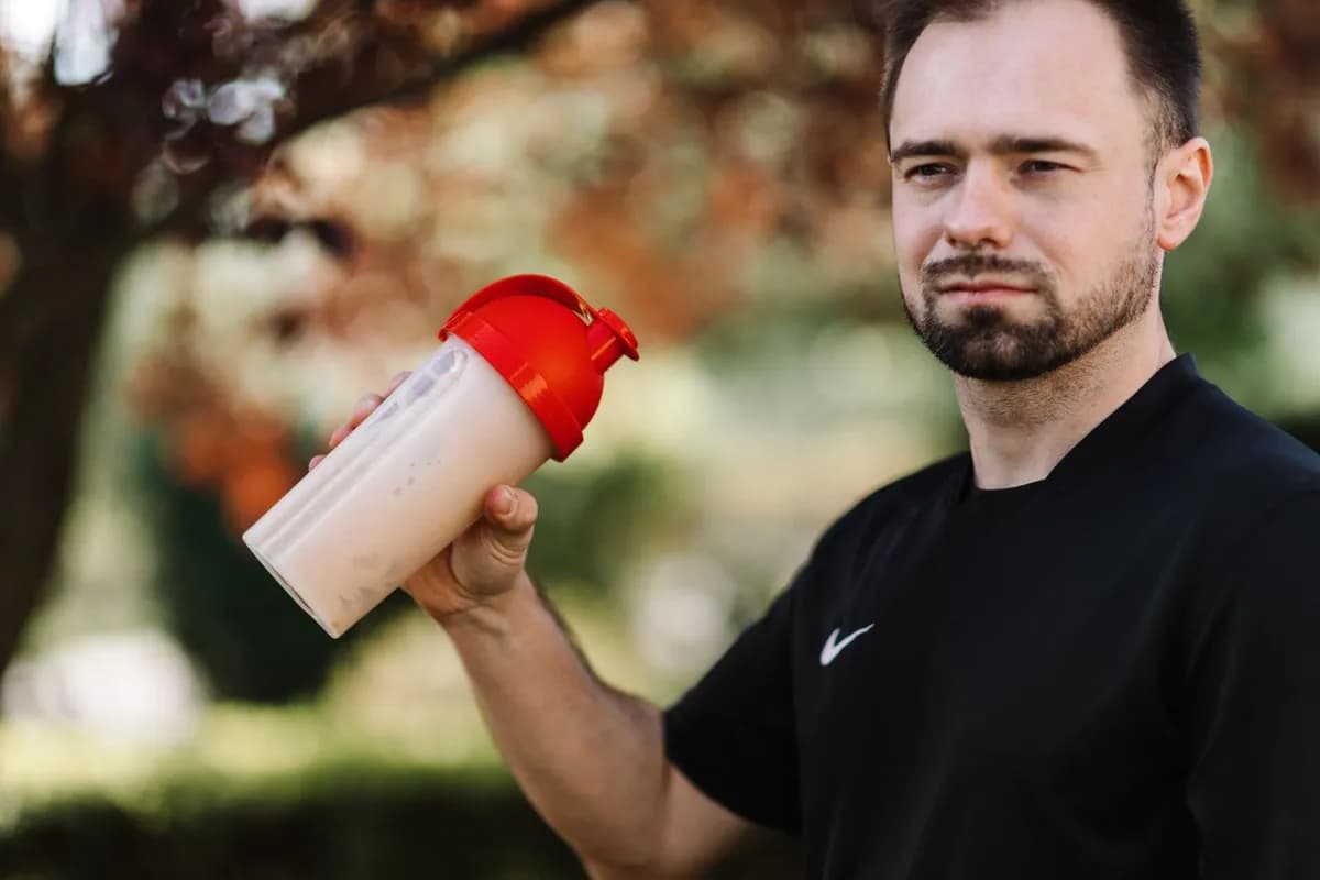 Man holding a protein shake — the evidence for creatine causing hair loss does not yet support a direct causal link