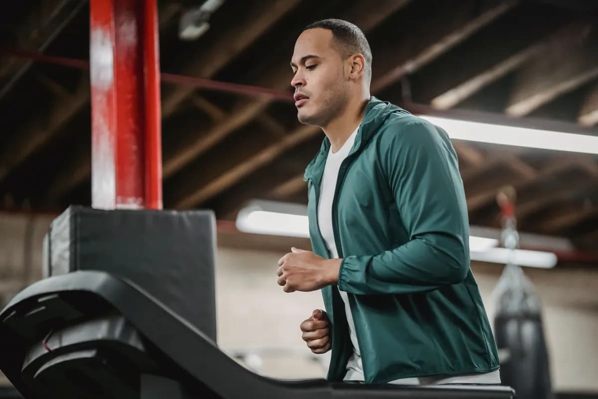 Man running on treadmill in gym — does working out cause hair loss