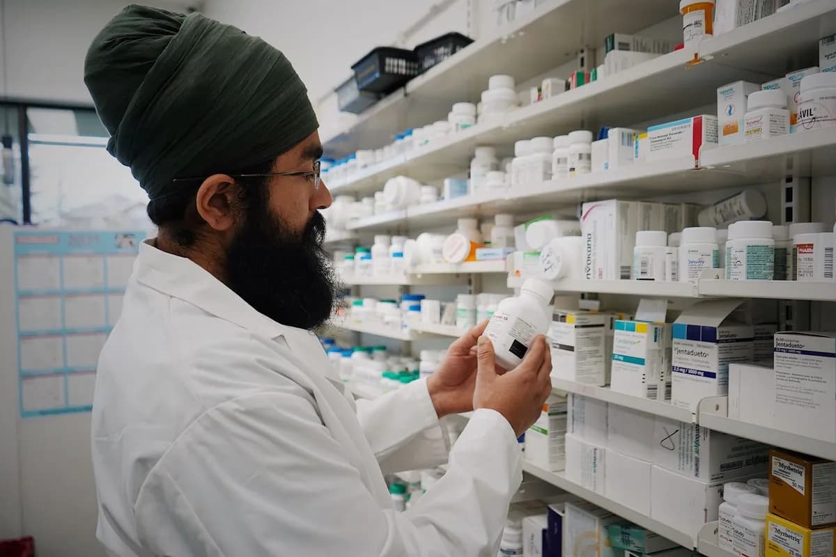Pharmacist in front of medicine shelves — topical hair-loss medication in Malta requires a specialist prescription